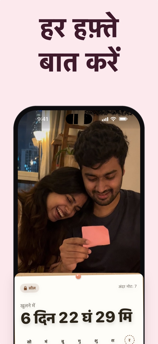 हर हफ़्ते चेक-इन करें: सोफ़े पर एक कपल, वह उसके कंधे पर सिर टिकाए है और वह उसका गुलाबी स्टिकी नोट पढ़ रहा है, ऊपर काउंटडाउन वाला सील बोर्ड